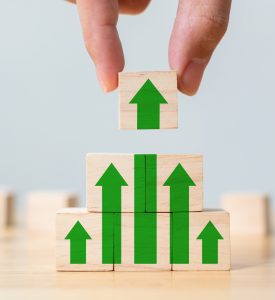 Ladder career path for business growth success process concept. Wood block stacking as step stair with arrow up. Hand putting wooden cube block on top pyramid Ladder career path for business growth success process concept. Wood block stacking as step stair with arrow up. Hand putting wooden cube block on top pyramid
