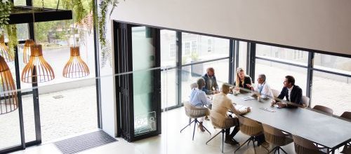 High angle view of a diverse group of businesspeople talking together around a conference table during a boardroom meeting in an office