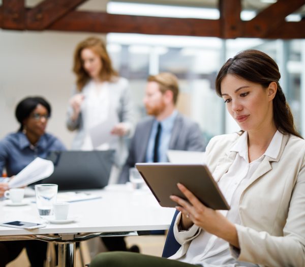 Young businesswoman using digital tablet and analyzing business report