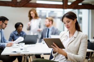 Young businesswoman using digital tablet and analyzing business report
